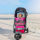 Medium size dog sitting inside the Petique Durable dog stroller parked on the beach.