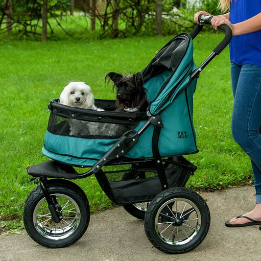 Two dogs riding inside Pet Gear Double Dog Stroller for large dogs in green color.