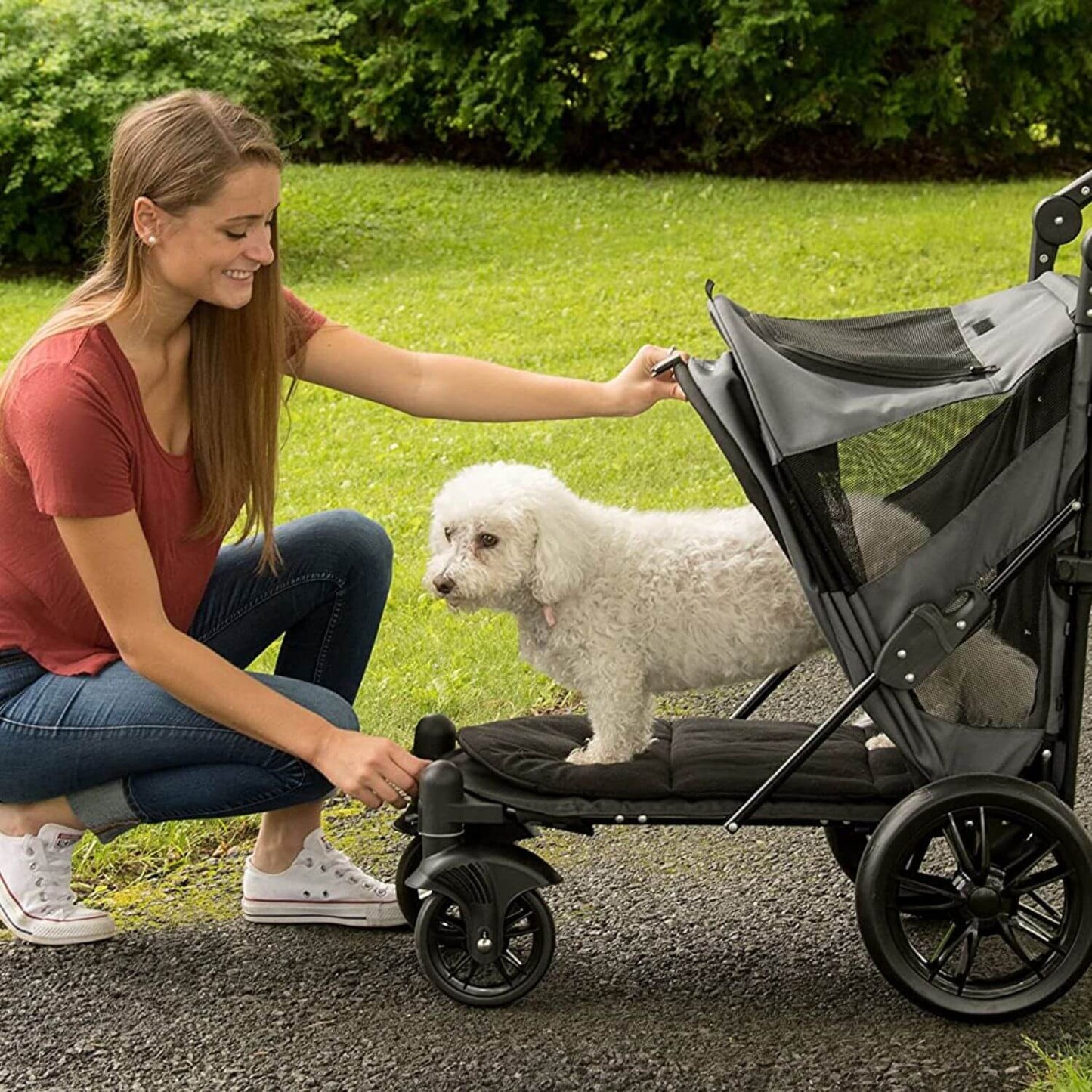 Person opening the canopy of the Pet Gear Excursion dog stroller with a push of a button.