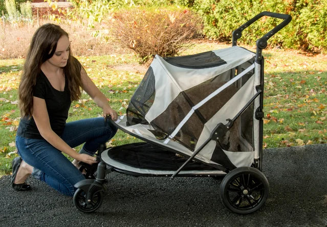 Person is lifting the canopy of the Pet Gear Expedition dog stroller.