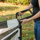 Person pressing the button to adjust handle on the Pet Gear Expedition dog stroller.